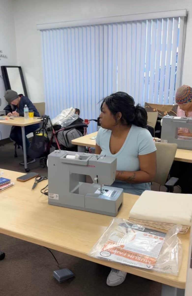 A Sewing for Success participant at her sewing machine in class